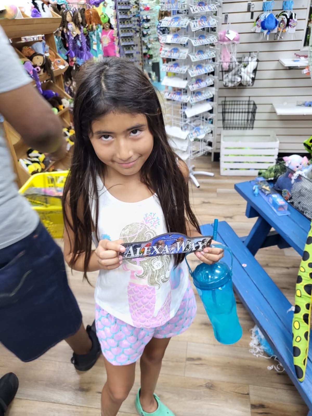Alexa holding a personalized 'Alexa Way' souvenir sign